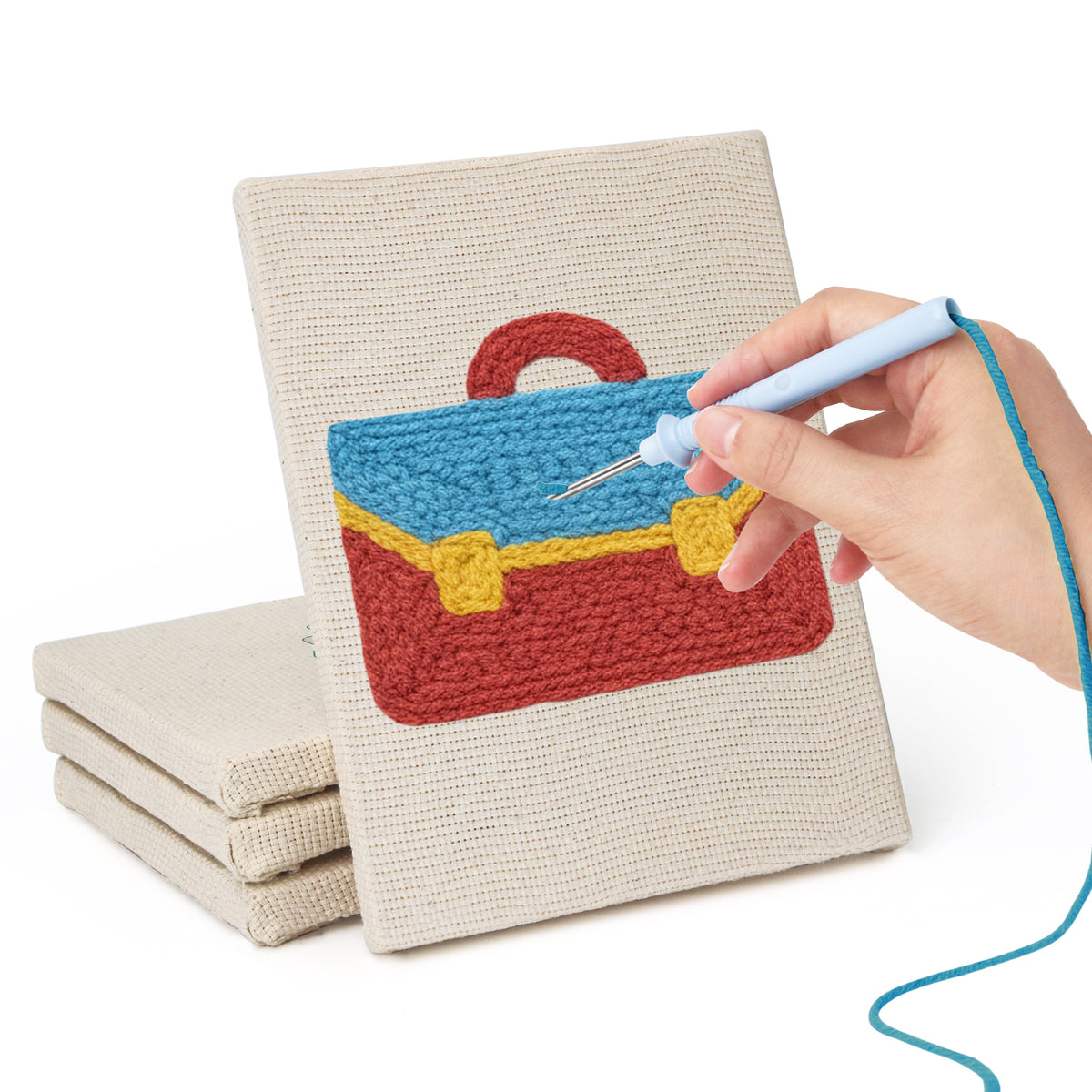 Hand punching one of the Graduation Satchel mini canvases