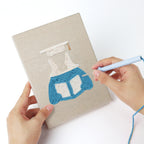 Punching a Graduation Satchel mini canvas with the punch needle