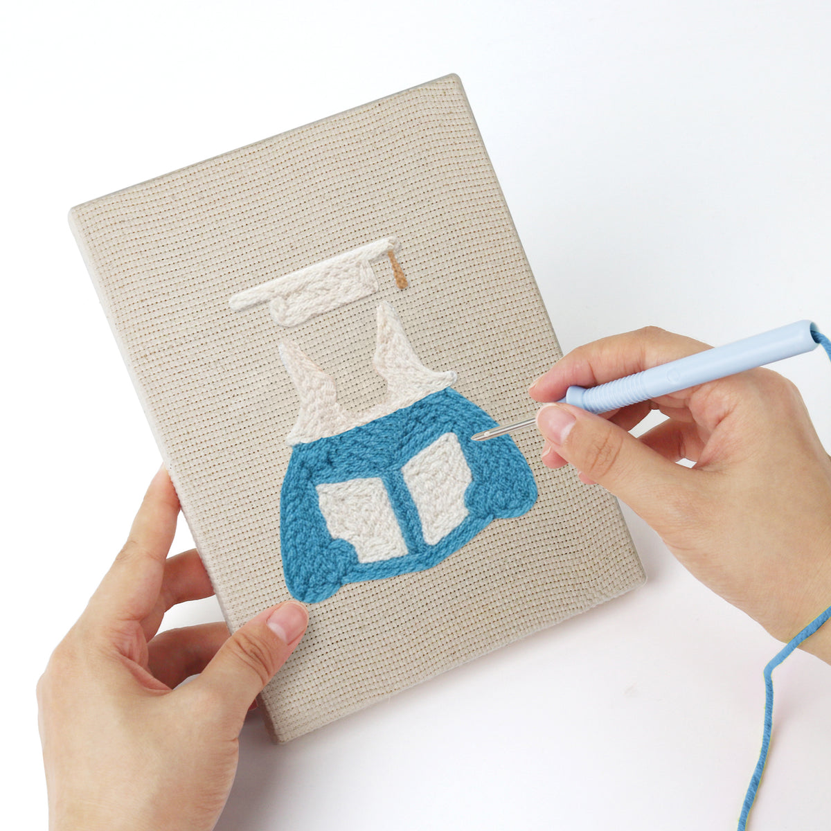 Punching a Graduation Satchel mini canvas with the punch needle