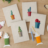 The four finished Gray Pot Cacti mini canvases laid out on a table