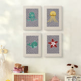 The four Gray Sea Friends mini canvases on a wall above a shelf