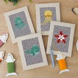 The four finished Gray Sea Friends mini canvases laid out on a table