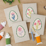 The four finished Green Egg Posies mini canvases laid out on a table
