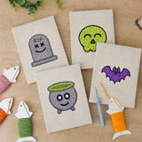 The four finished Green Skull Cauldron mini canvases laid out on a table