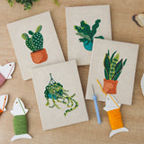 The four finished Hanging Plant Corner mini canvases laid out on a table