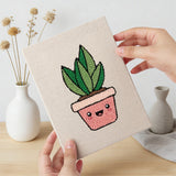 Hand holding a finished Happy Little Planters mini canvas