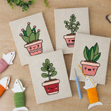 The four finished Happy Little Planters mini canvases laid out on a table