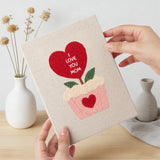 Hand holding a finished Hearts and Bouquets mini canvas