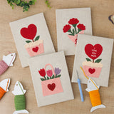 The four finished Hearts and Bouquets mini canvases laid out on a table
