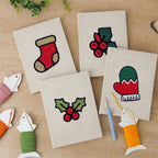 The four finished Holly and Mitten mini canvases laid out on a table