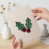 Hand holding a finished Holly and Sprig mini canvas