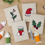The four finished Holly and Sprig mini canvases laid out on a table