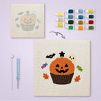 Jack-o'-Lantern Cupcake canvas before and after punching, with the threads and tools