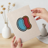 Hand holding a finished Jelly Bean Pops mini canvas