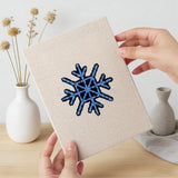 Hand holding a finished Jingle Bells Snowflake mini canvas