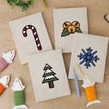 The four finished Jingle Bells Snowflake mini canvases laid out on a table