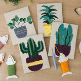 The four finished Leafy Houseplants mini canvases laid out on a table