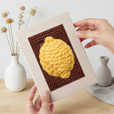 Hand holding a finished Lemon and Broccoli mini canvas