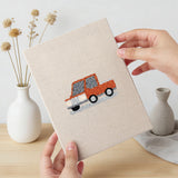 Hand holding a finished Little City Cars mini canvas