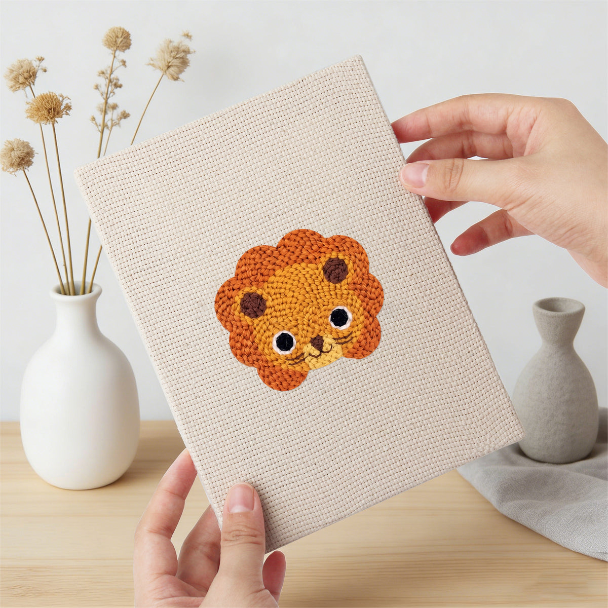 Hand holding a finished Little Zoo Faces mini canvas