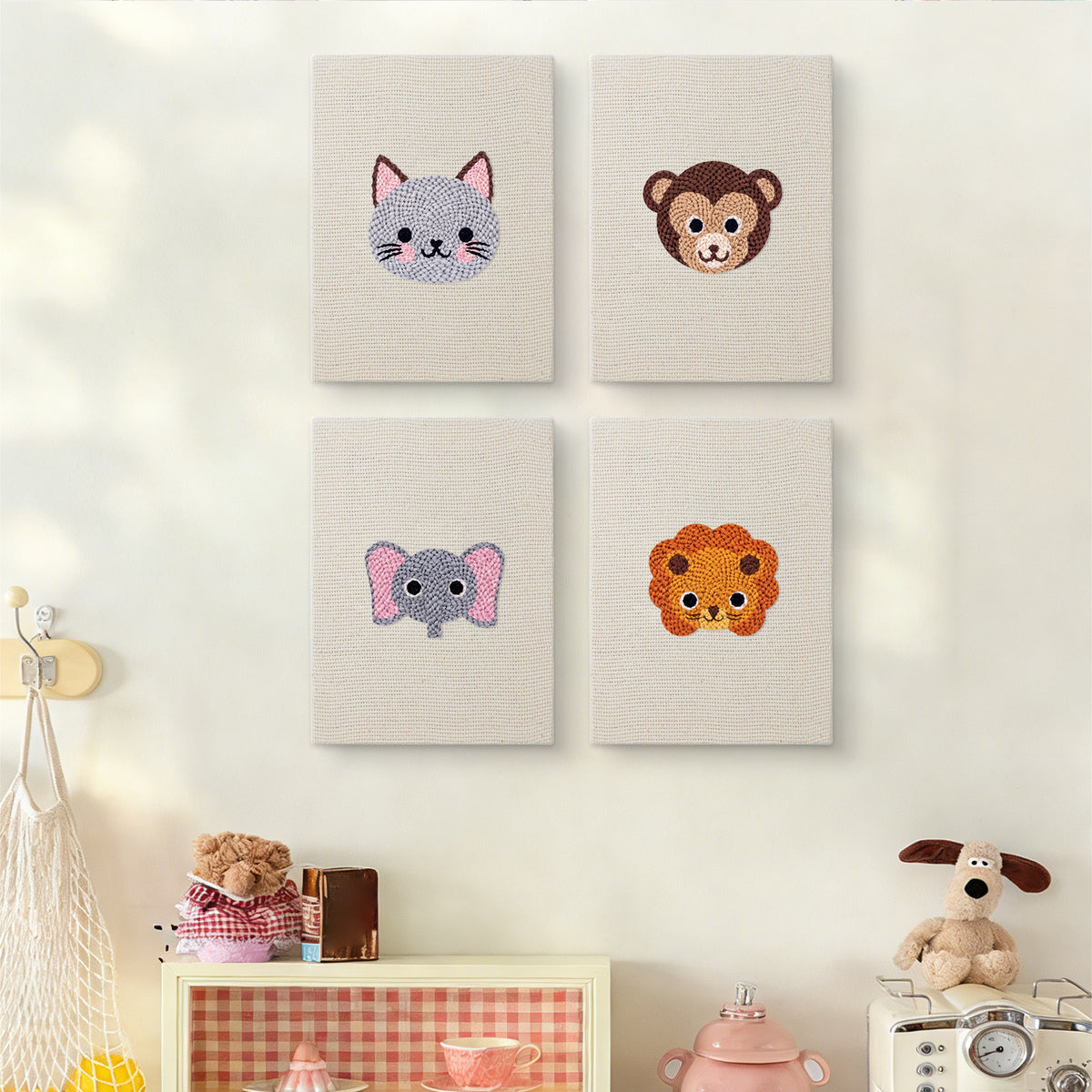 The four Little Zoo Faces mini canvases on a wall above a shelf