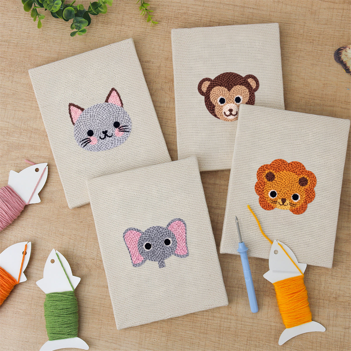 The four finished Little Zoo Faces mini canvases laid out on a table