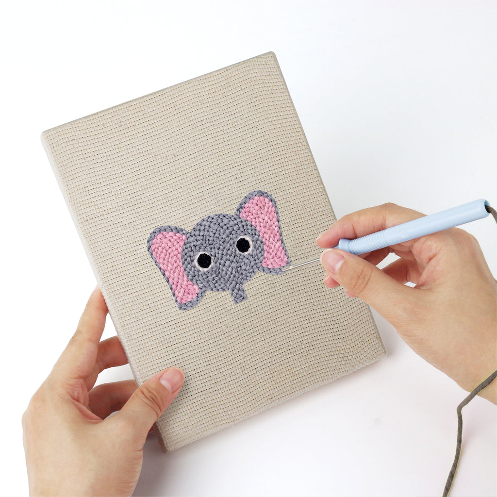 Punching a Little Zoo Faces mini canvas with the punch needle