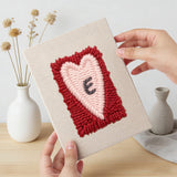 Hand holding a finished Love Letter Hearts mini canvas