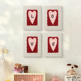 The four Love Letter Hearts mini canvases on a wall above a shelf