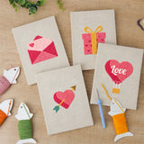 The four finished Love Note Hearts mini canvases laid out on a table