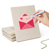 Hand punching one of the Love Note Hearts mini canvases