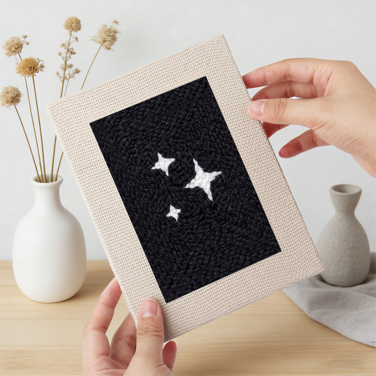 Hand holding a finished Midnight Ghost mini canvas