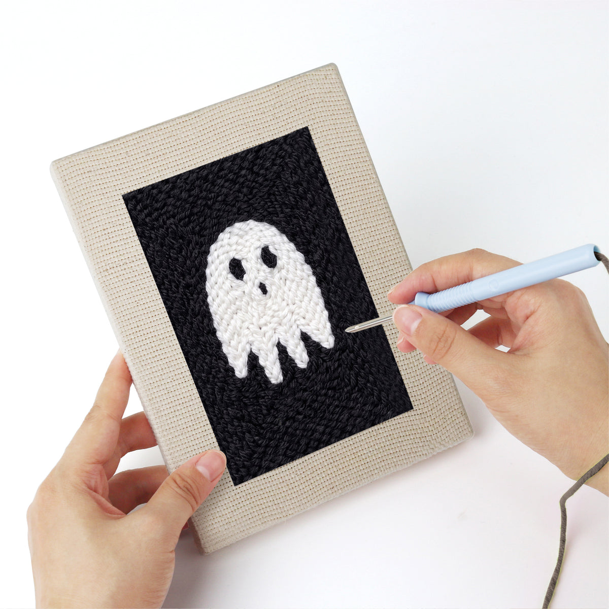 Punching a Midnight Ghost mini canvas with the punch needle