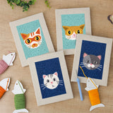 The four finished Navy Teal Cats mini canvases laid out on a table