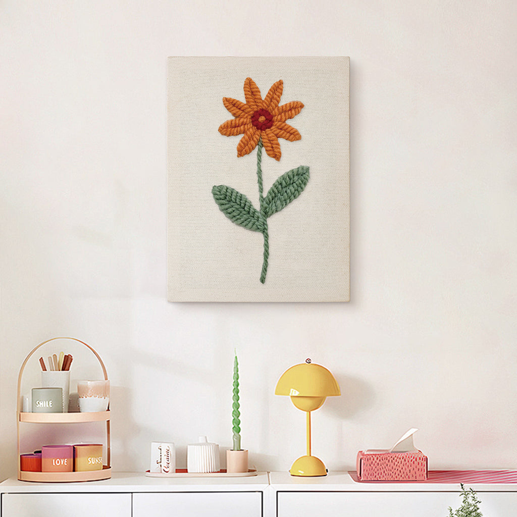Finished Orange Daisy punch needle canvas on a wall