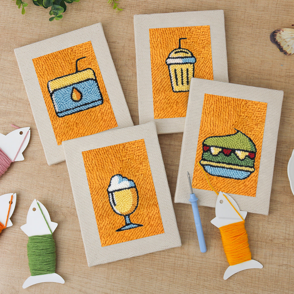 The four finished Orange Drink Stand mini canvases laid out on a table