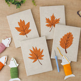 The four finished Orange Maple Leaves mini canvases laid out on a table