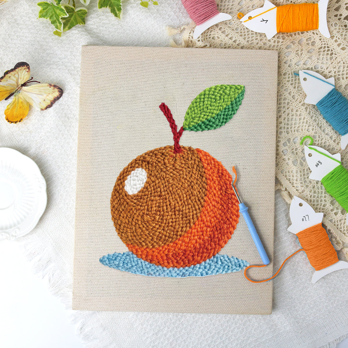 Orange on Blue canvas before and after punching, with the threads and tools