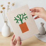 Hand holding a finished Orange Pot Greens mini canvas
