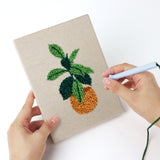 Punching a Orange Pot Plants mini canvas with the punch needle