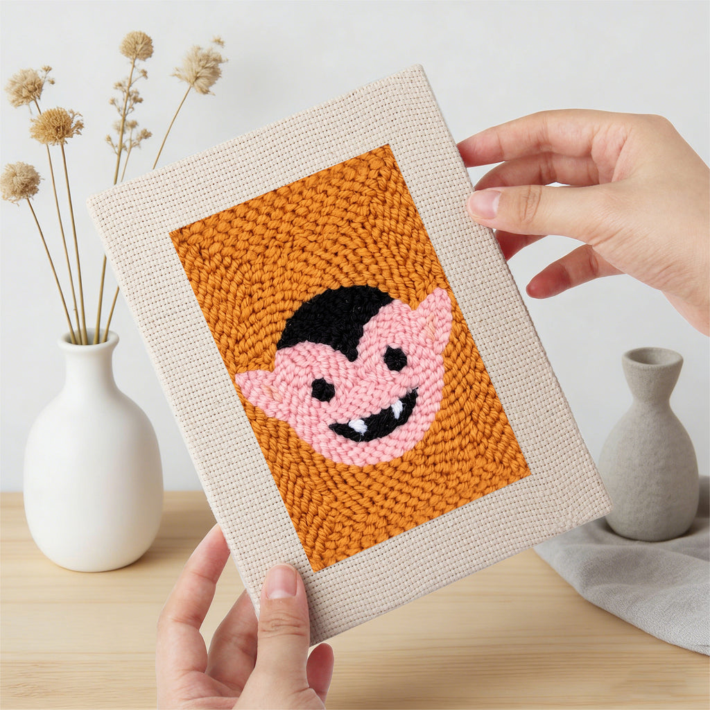 Hand holding a finished Orange Spiderweb mini canvas