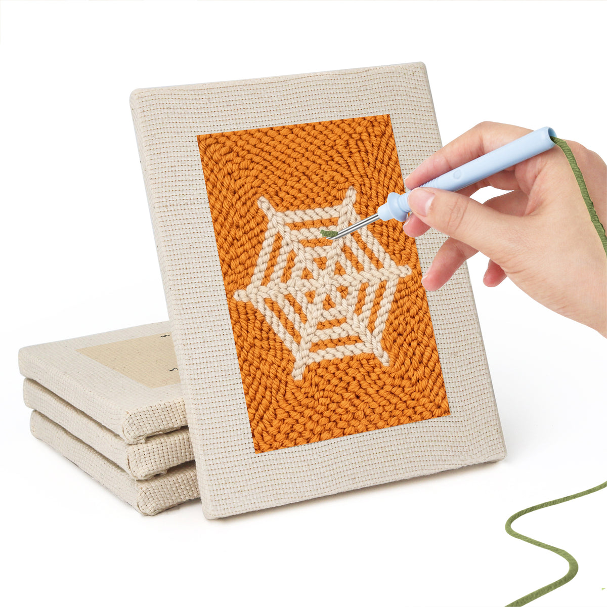 Hand punching one of the Orange Spiderweb mini canvases