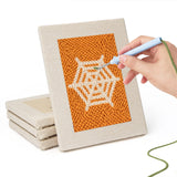 Hand punching one of the Orange Spiderweb mini canvases