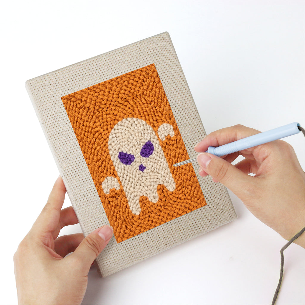 Punching a Orange Spiderweb mini canvas with the punch needle