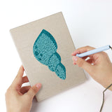 Punching a Pastel Seashells mini canvas with the punch needle