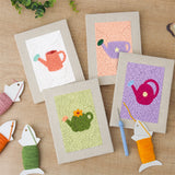 The four finished Pastel Watering Cans mini canvases laid out on a table