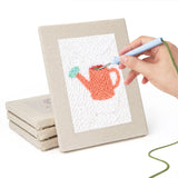 Hand punching one of the Pastel Watering Cans mini canvases