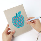 Punching a Patterned Apples mini canvas with the punch needle