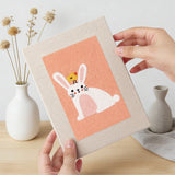 Hand holding a finished Peach Easter Bunnies mini canvas