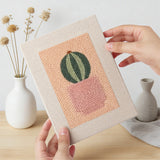 Hand holding a finished Peach Succulents mini canvas